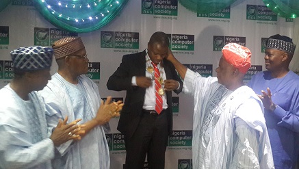‎Professor Adesola Aderounmu, president, Nigeria Computer Society (NCS), ‎being decorated by the immediate past president, Professor David Adewumi, while other past president watch. ‎